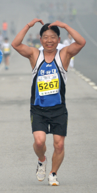 ▲ <“사랑해요”> 전주 전국마라톤대회에 참가한 마라토너가 달리며 하트 팔동작을 보이고 있다.
