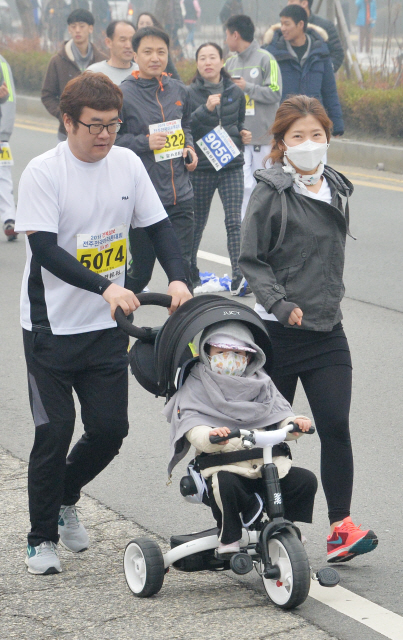 ▲ <온 가족이 함께> 아이와 함께 대회에 참가한 부부가 세발자전거를 밀며 달리고 있다.
