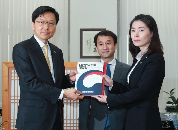 26일 오후 국회 본청에서 김외숙 법제처장 등이 문재인 대통령이 발의한 정부 개헌안(대한민국헌법 개정안)을 진정구 국회 입법차장에게 제출하고 있다. 왼쪽부터 진정구 입법차장, 한병도 청와대 정무수석, 김외숙 법제처장. /연합뉴스