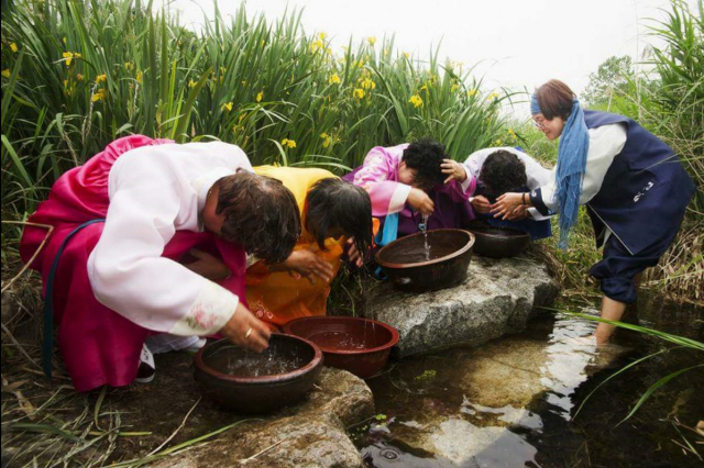 ▲ 완주 안남마을 단오 창포행사에서 주민들이 창포물로 머리를 감고 있다.