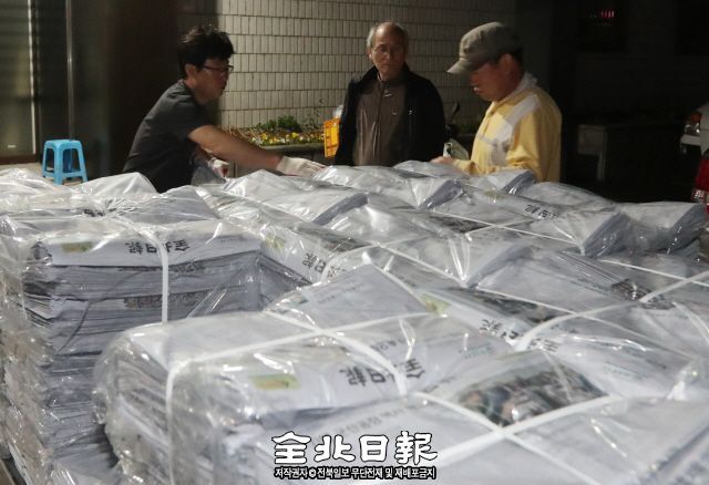 ▲ 지난달 30일 오후 10시 50분께 인쇄소에서 도착한 발송차량에서 배달 기사들이 신문을 옮기고 있다.  조현욱 기자