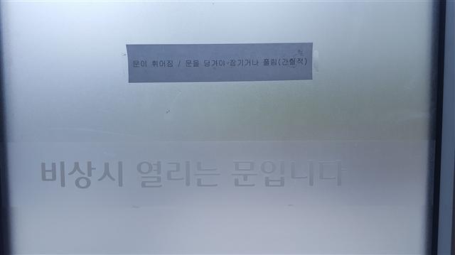 ▲ 한 쇼핑몰 비상출입문에는 ‘문이 휘어짐/문을 당겨야 잠기거나 풀림(간헐적)’이라고 적혀있다.