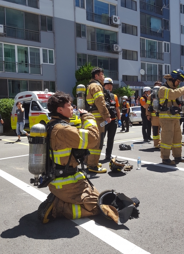찜통 더위에 무거운 장비를 매고 10층까지 올라가 화재를 진압한 소방대원이 갈증에 목을 축이고 있다. 사진=독자 제공