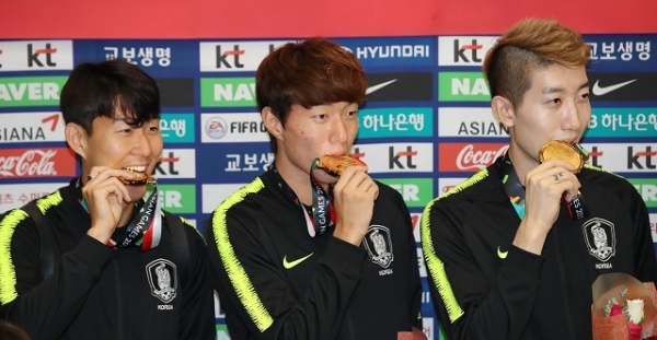 2018 자카르타-팔렘방 아시안게임에서 금메달을 획득하며 대회 2연패를 달성한 축구대표팀 손흥민(왼쪽부터), 황의조, 조현우가 3일 오전 인천국제공항으로 귀국한 뒤 해단식에서 금메달을 입에 물고 있다. 연합뉴스