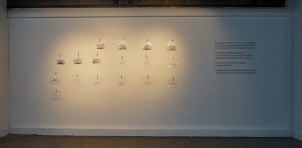 전시장 입구에 붙어 있는 모금액이 담긴 비닐팩.