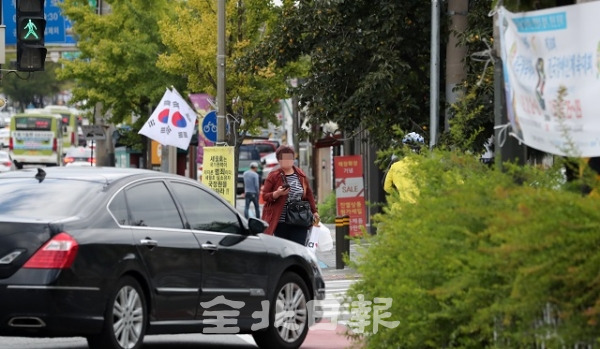 1일 병무청 오거리 우회전 차량에 사람 키만한 화단과 현수막 등이 걸려있어 운전자와 보행자들이 불편을 겪고 있다. 조현욱 기자