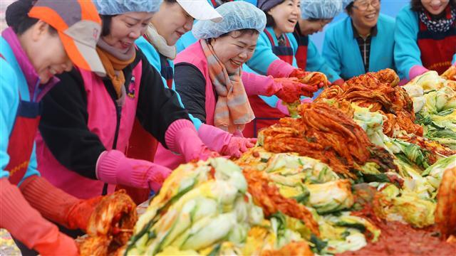 김장철을 맞아 소외된 이웃을 위한 사랑의 김장김치 담그기 행사에서 전주여성자원활동센터 봉사자들이 김치를 담그며 웃음짓고 있다.