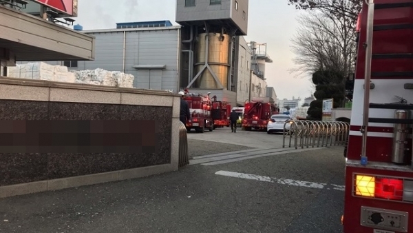 담보다 높게 쌓인 적재물로 인해 대형 소방차가 진입하지 못하고 도로에 서있다. 소형 소방차들만이 진입해 불을 끄고 있다.