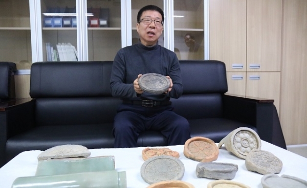 김성호 씨가 30여년 넘게 수집한 기와를 들어 보이고 있다.