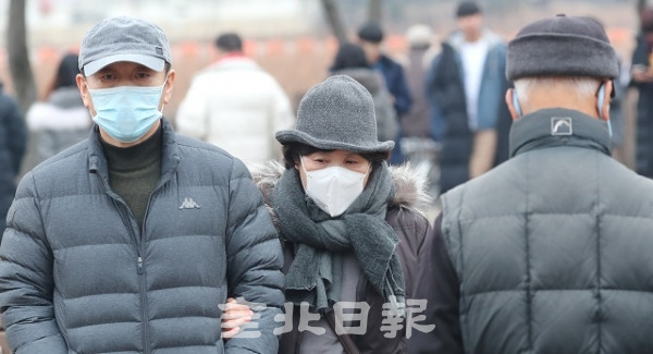 미세먼지 '나쁨'을 기록한 22일 전주 덕진공원을 찾은 시민들이 마스크 등으로 입과 코를 가리고 발걸음을 옮기고 있다. 조현욱 기자