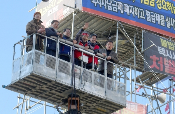 택시회사의 전액관리제(완전월급제) 도입을 요구하며 전북 전주시청 망루에서 510일간 농성을 해왔던 김재주(오른쪽 세번째) 민주노총 택시노조 전북지회장이 동료들과 함께 망루에서 내려오고 있다. /연합뉴스