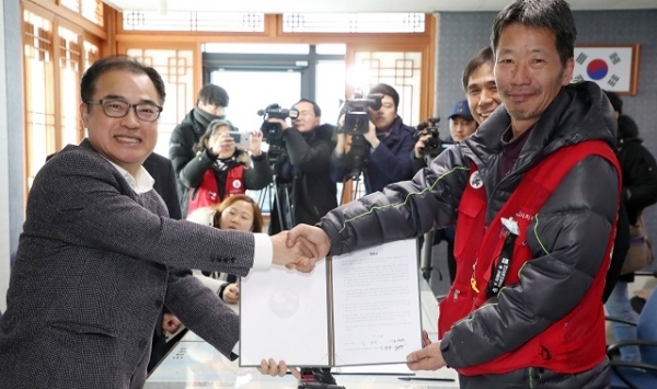 26일 전주시청에서 김양원 전주시 부시장과 김영만 공공운수노조 택시지부장이 택시월급제인 전액관리제를 위한 확약서에 서명 후 손을 잡고 있다. 사진제공 = 전주시