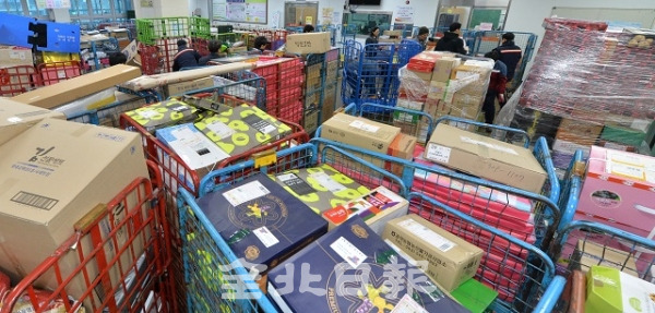설 명절을 앞두고 명절선물 택배물량이 몰린 29일 전주우체국에 쌓인 택배물량 사이로 직원들이 분주하게 움직이고 있다. 박형민 기자