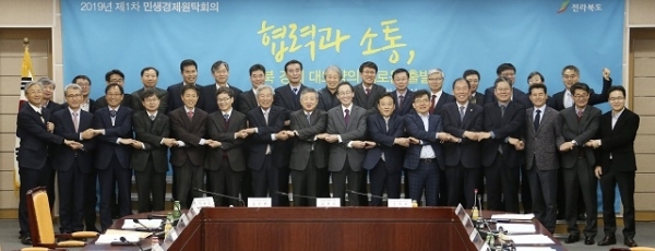 14일 도청 종합상황실에서 열린 2019년 제1차 전라북도 민생경제원탁회의에 송하진 지사와 이원택 정무부지사를 비롯한 도내 경제 관련 유관기관장 및 관계자들이 참석하여 전북 주요 시책 공유와 기관 간 협력 사항에 대해 논의를 나누고 전북경제 활성화를 위해 손을 맞잡고 기념촬영을 하고 있다. 사진제공= 전북도