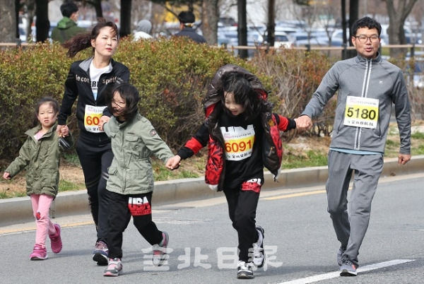2019 전북일보 전주전국마라톤대회에 참가한 가족이 손을 잡고 결승점을 향해 뛰고 있다.