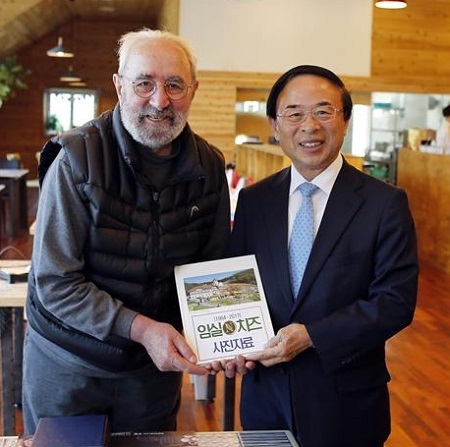 지난 2017년 5월 22일, 지정환 신부(왼쪽)가 심민 임실군수에게 자신이 1964년 임실성당에 부임한 이후 현재까지의 활동한 자료를 전달하고 있다.