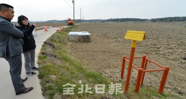 지난 9일 군산시 미 공군비행장 인근에 위치한 논에 설치된 송유관 시설 앞에서 본보 기자와 녹색연합 관계자가 이야기를 나누고 있다. 박형민 기자