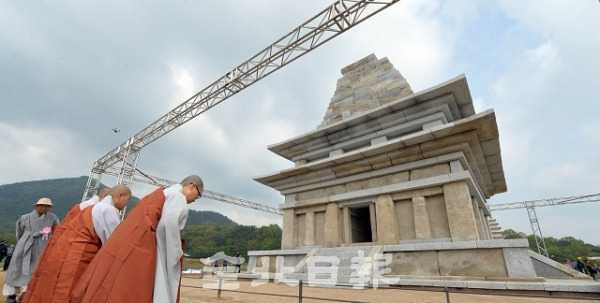 1999년 보수를 시작해 준공까지 20년이 걸린 익산 미륵사지석탑 보수 준공식이 열린 지난 30일 익산시 미륵사지에서 승려들이 가림막을 걷은 탑을 보며 합장을 하고 있다. 박형민 기자
