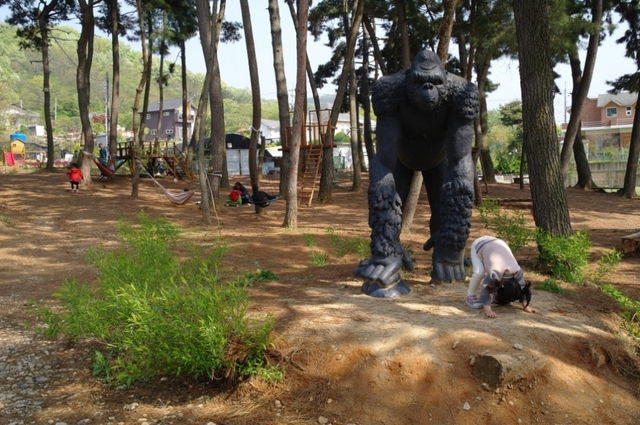 숲속 놀이터 앞 킹콩 조형물. 딸아이가 킹콩 자세를 따라 한다.
