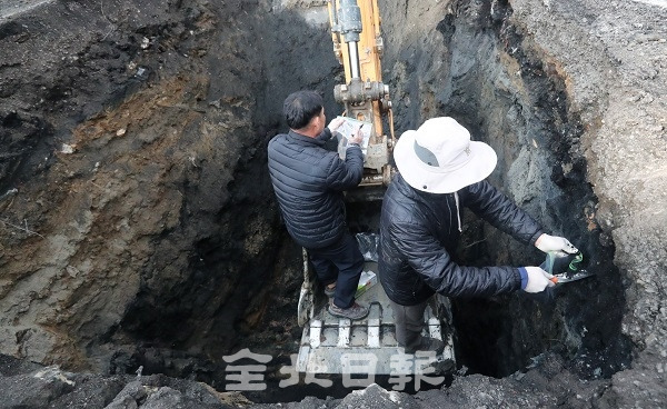 지난해 12월 익산시와 국립환경과학원, 환경부로 구성된 조사팀이 장점 마을 부근 비료공장의 전수조사가 시작된 가운데 주민들이 주장하는 폐기물 매립 장소에 굴을 파고 시료를 채취하고 있다. 전북일보 자료사진
