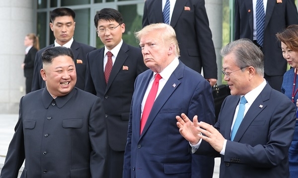 김정은 북한 국무위원장이 30일 판문점 남측 자유의 집에서 도널드 트럼프 미국 대통령과 회동을 마친 뒤 문재인 대통령 등과 함께 군사분계선으로 이동하고 있다. 연합뉴스