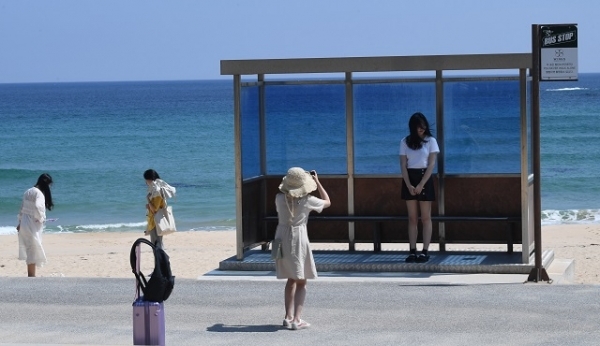 강릉 주문진해변 방탄소년단 뮤직비디오 촬영 버스승강장에서 관광객들이 추억을 남기고 있다. 사진=강원일보 권태명 기자