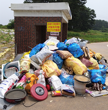 김제 성덕면 내 버스 정류장에 쌓여 있는 쓰레기더미.