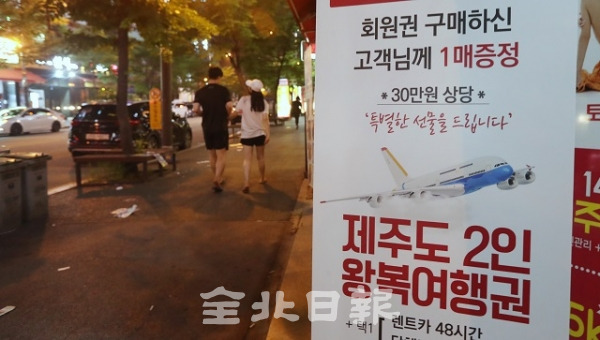21일 전주 신시가지의 한 매장 앞에 회원권을 구매하면 제주도 왕복여행권을 준다는 입간판이 걸려있다. 조현욱 기자