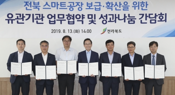 전북 스마트공장 보급과 확산을 위한 업무협약 및 성과나눔 간담회가 13일 완주산단 대륜산업에서 열린 가운데 송하진도지사와 김종호 삼성전자 사장, 김광재 전북지방중소벤처기업청장을 비롯한 유관기관장들이 업무협약을 갖고 기념촬영을 하고있다. 왼쪽부터 김상헌 한국표준협회 전북본부 본부장 ,조한교 중소벤처기업진흥공단 전북본부 본부장, 김정원 중소기업중앙회 전북지역본부 본부장, 송하진도지사, 김종호 삼성전자 사장, 김광재 전북지방중소벤처기업청 청장, 신은수 전북테크노파크 단장. 사진제공=전북도