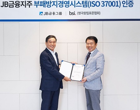 지난달 30일 서울 여의도 JB빌딩에서 JB금융그룹 김기홍 회장(왼쪽)이 BSI 코리아 송경수 총괄 책임으로부터 ISO 37001 인증서를 수여 받는 모습.