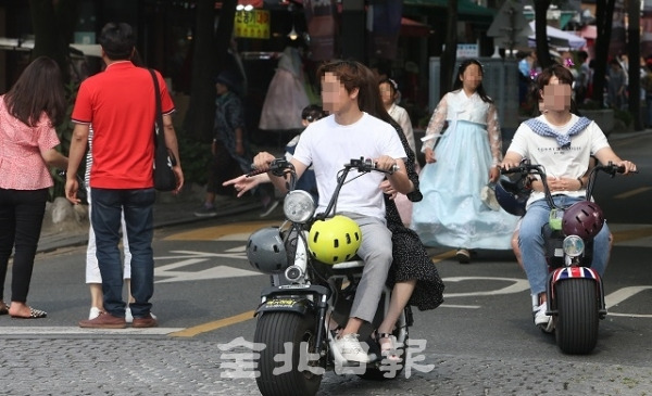 지난 1일 전주 한옥마을에서 안전장비를 착용하지 않은 전동스쿠터를 탄 운전자들이 관광객 사이로 지나고 있다. 조현욱 기자