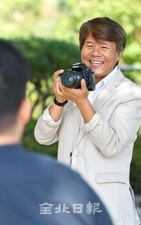 18일 전라북도장애인복지관에서 사회복지사와 사진작가로 활동하고 있는 오준규 팀장이 환한 웃음과 함께 사진 촬영을 하고 있다. 박형민 기자