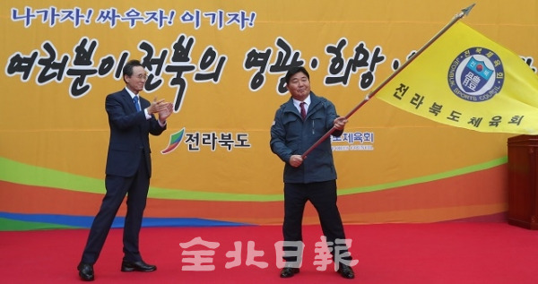 제100회 전국체육대회 전라북도선수단 결단식이 전북체육회 광장에서 열린 23일 최형원 전북체육회 사무처장(총감독)이 송하진 도지사에게 수여 받은 단기를 힘껏 흔들고 있다. 조현욱 기자