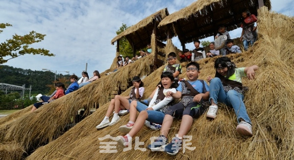 완주 와일드푸드축제 개막을 하루 앞둔 26일 행사장인 고산자연휴양림 일원에서 아이들이 볏짚 미끄럼틀을 타며 웃음짓고 있다. 박형민 기자
