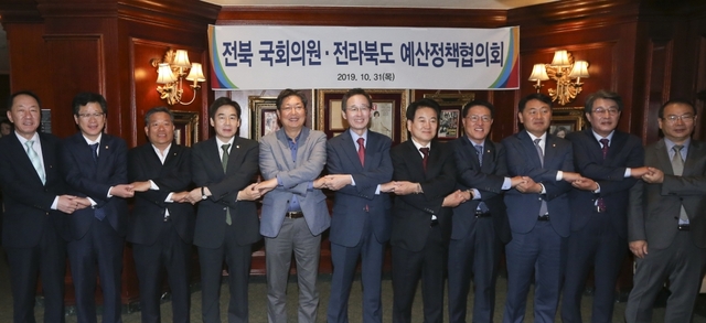 31일 서울 여의도 컨싱턴호텔에서 열린 전북 국회의원과 전북도의 예산정책협의회에 송하진 도지사를 비롯한 국회의원들이 2020년 국가예산확보를 위해 손을 맞잡고 있다. 사진제공 = 전북도