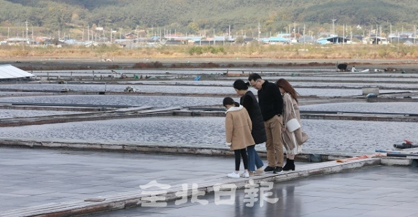 11일 최근 사진 촬영지로 유명세를 탄 부안 곰소리의 천일염 생산 염전에서 관광객들이 염전을 구경하며 즐거운 시간을 보내고 있다. 조현욱 기자