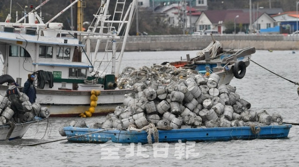 지난 24일 군산시 무녀도 인근 해상에서 양식 관리선이 전복돼는 사고가 발생한 가운데 25일 무녀도 선착장에 정박된 양식 관리선에서 어민들이 작업을 하고 있다. 박형민 기자