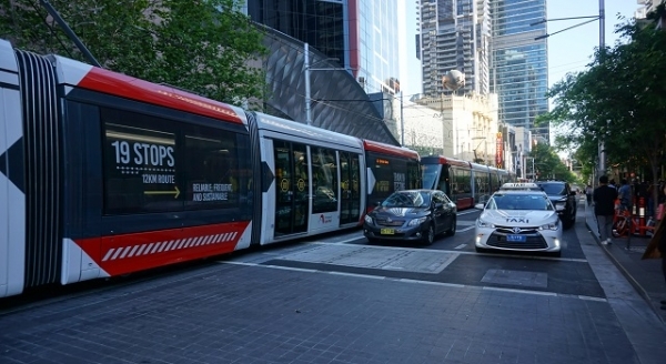 호주 시드니 거리에서 차량과 트램이 다니고 있다.