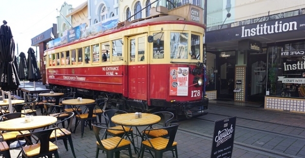 뉴질랜드 크라이스트 처치 트램이 상가 사이로 지나가는 모습.
