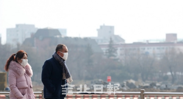 올해 첫 미세먼지 비상저감조치가 발령된 4일 미세먼지로 뿌옇게 변한 전주시 덕진공원에서 시민들이 마스크를 쓰며 발걸음을 옮기고 있다. 조현욱 기자