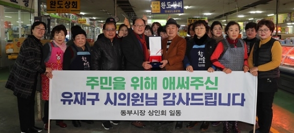 유재구 익산시의회 기획행정위원장이 동부시장 상인회로부터 감사패를 받고 기념촬영을 하고 있다.