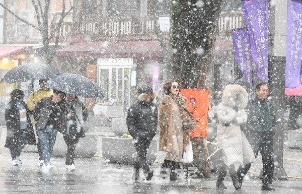 따뜻한 봄날씨가 이어지다 봄이 오는 것을 시샘하듯 꽃샘추위와 함께 눈바람이 찾아온 16일 전주한옥마을을 찾은 관광객들이 올 겨울 보기 힘들었던 눈을 맞으며 한옥마을을 둘러보고 있다. 오세림 기자