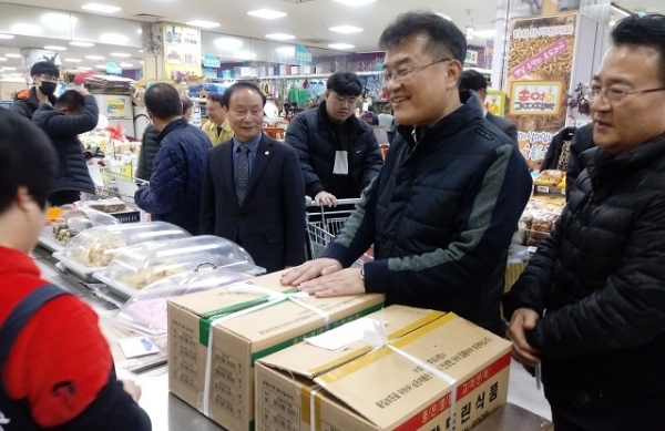19일 윤종인 행안부 차관이 군산공설시장을 방문해 물건을 구매하며 상인과 대화를 나누고 있다.