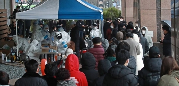 서울 구로구 신도림동 코리아빌딩 11층에 있는 콜센터에서 발생한 코로나19 집단 감염으로 지난 10일 빌딩 외부에 설치된 선별진료소 앞에서 입주자들이 코로나19 검진을 받기 위해 줄지어 서있다. 연합뉴스