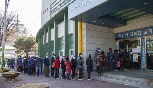 익산시의 면 마스크 무료 배부 소식을 듣고 아침 일찍 발걸음 재촉에 나선 영등1동 주민들이 영등1동 행정복지센터 앞에서 문이 열리기만을 기다리며 줄을 길게 늘어서 있다.