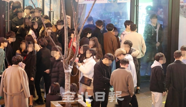 코로나19 감염 차단을 위한 '사회적 거리두기'가 진행되고 있는 가운데 지난 13일 전주 서부신시가지에서 시민들이 한 주점에 들어가기 위해 다닥다닥 붙어 있어 우려를 주고 있다. 조현욱 기자