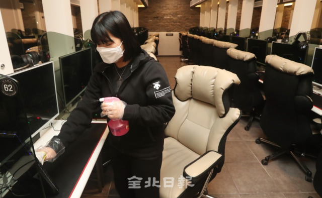 전주 시민 일제 소독의 날인 18일 코로나19 집단 감염의 위험성이 있는 전주시의 한 PC방에서 직원이 컴퓨터와 의자에 소독을 하며 감염을 예방하고 있다. 조현욱 기자