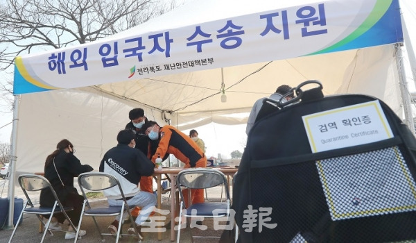 해외 입국자로 인한 코로나19 감염자가 늘어나고 있는 30일 전주월드컵경기장 해외 입국자 수송 지원 천막에서 의료진들과 공무원들이 인천국제공항에서 출발해 전주로 도착한 승객들의 이동 경로와 증상을 확인하며 코로나19 확산 방지에 총력을 기울이고 있다. 조현욱 기자