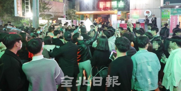 지난 10일 전북대학교 대학로의 한 술집에 유명 인터넷 방송인이 온다는 소식이 퍼지자 많은 인파가 몰려 정부의 사회적 거리두기 캠페인이 무색해지고 있다. 조현욱 기자