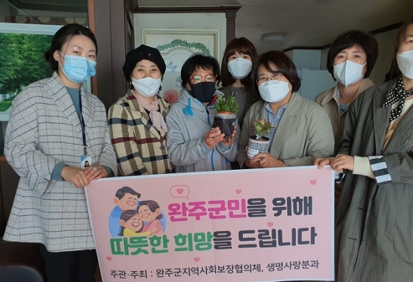 완주군 지역사회보장협의체 생명사랑분과와 마음꽃복지센터가 코로나19로 어려움을 겪고 있는 취약계층에 마스크와 화분을 전달했다.